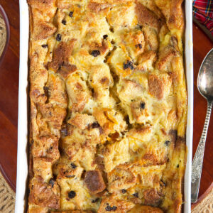 A white casserole dish is filled with baked bread pudding.