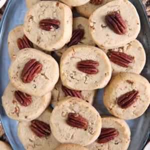A big batch of pecan sandies are placed on an oval serving platter.