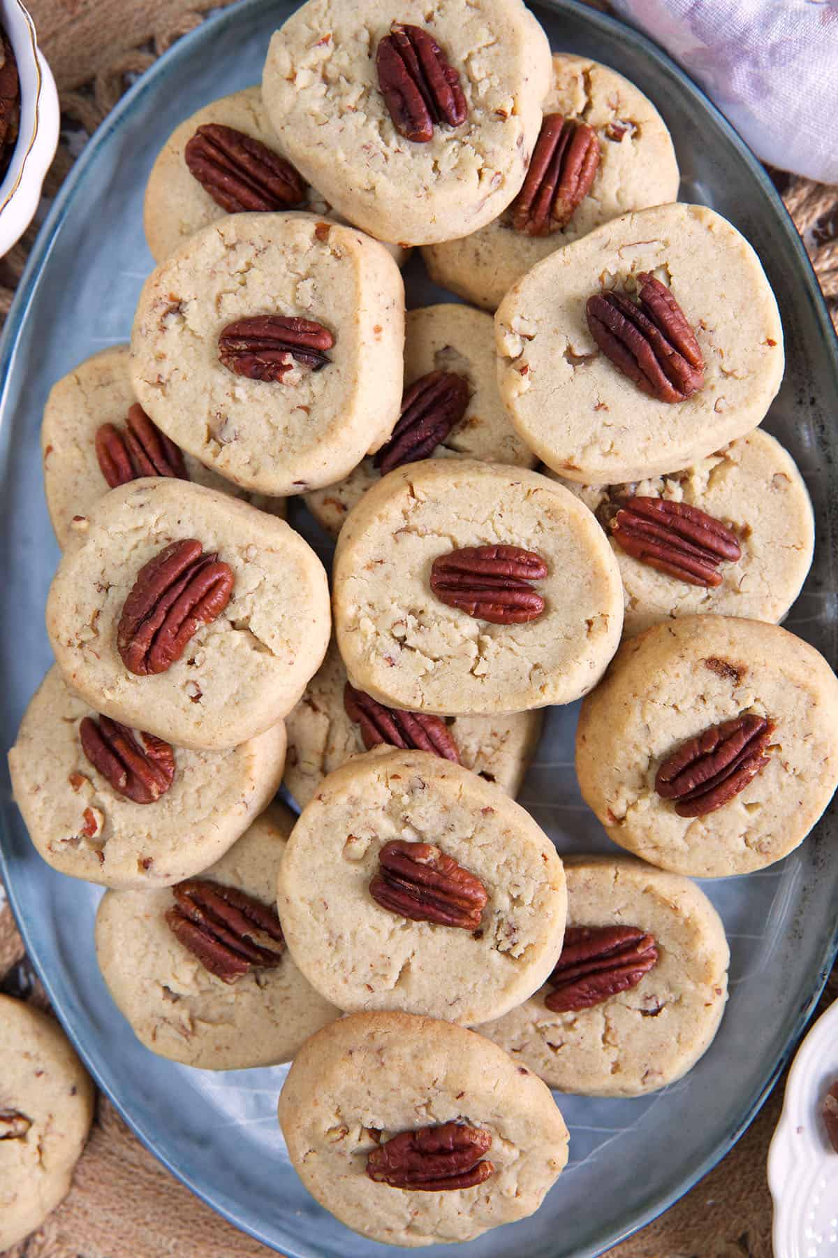 A big batch of pecan sandies are placed on an oval serving platter.