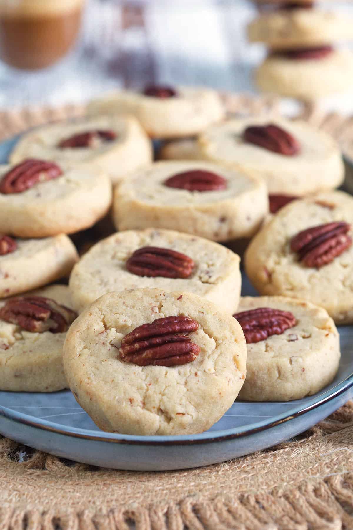 A large batch of pecan sandies is presented on an oval shaped platter.