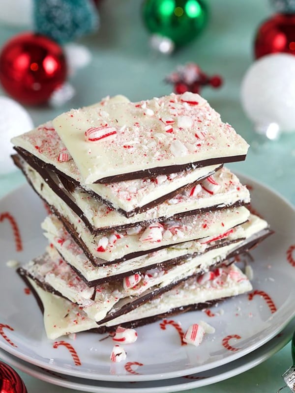 Peppermint Bark stacked on a plate with ornaments in the background.