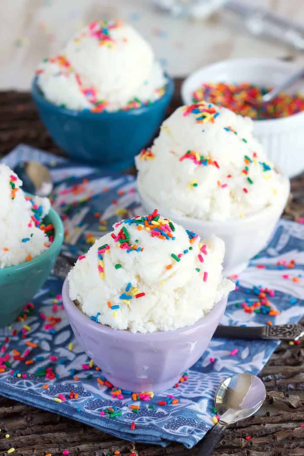 Four bowls of snow ice cream topped with rainbow sprinkles.