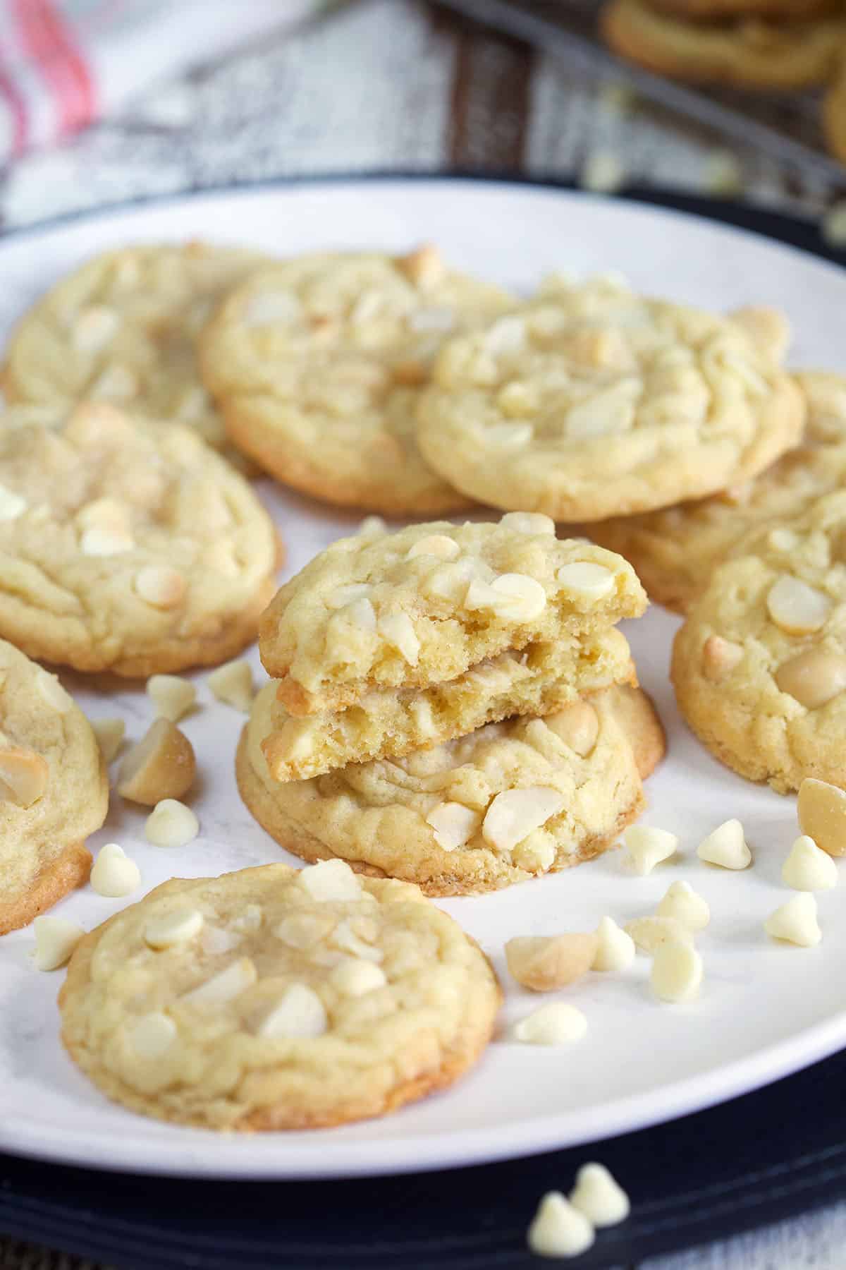 A plate of cookies is sprinkled with extra white chocolate chips.