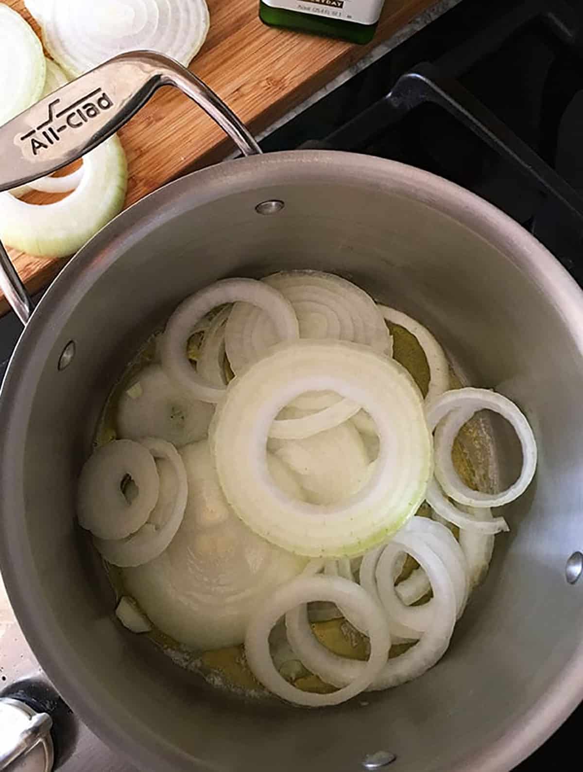 stock pot filled with sliced onions and olive oil.