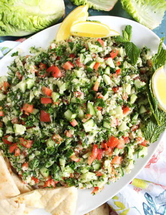 Cauliflower Tabbouleh Salad on a white platter with pita wedges.