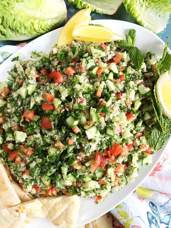 Cauliflower Tabbouleh Salad on a white platter with pita wedges.