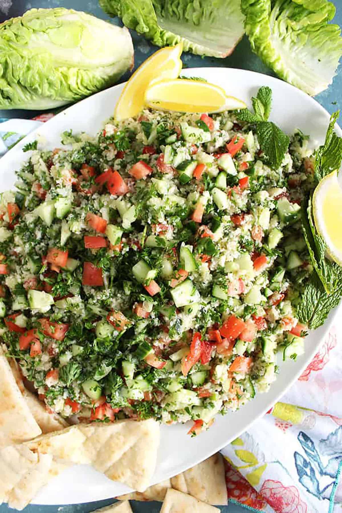 Cauliflower Tabbouleh Salad on a white platter with pita wedges.