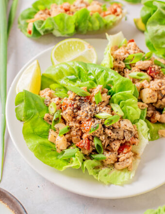 Multiple lettuce wraps are presented on a white plate.