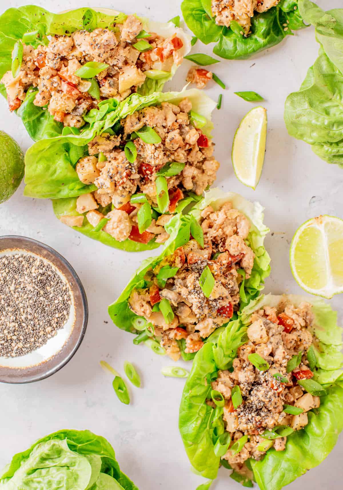 Several chicken lettuce wraps are placed on a white surface.