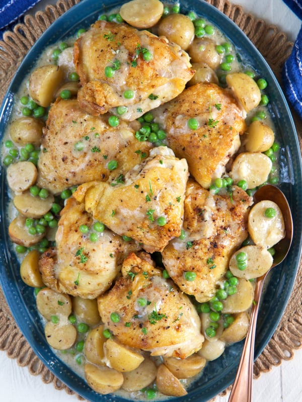A platter of chicken vesuvio is presented on a round placemat.
