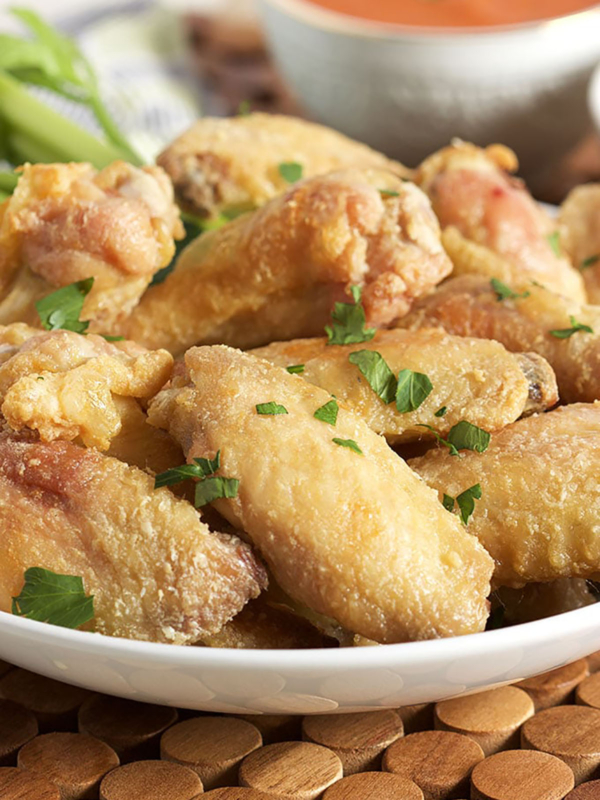 Crispy baked chicken wings in a white bowl.