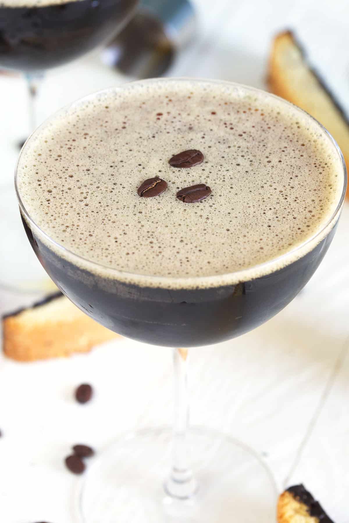 A martini glass is filled to the brim and topped with three coffee beans.
