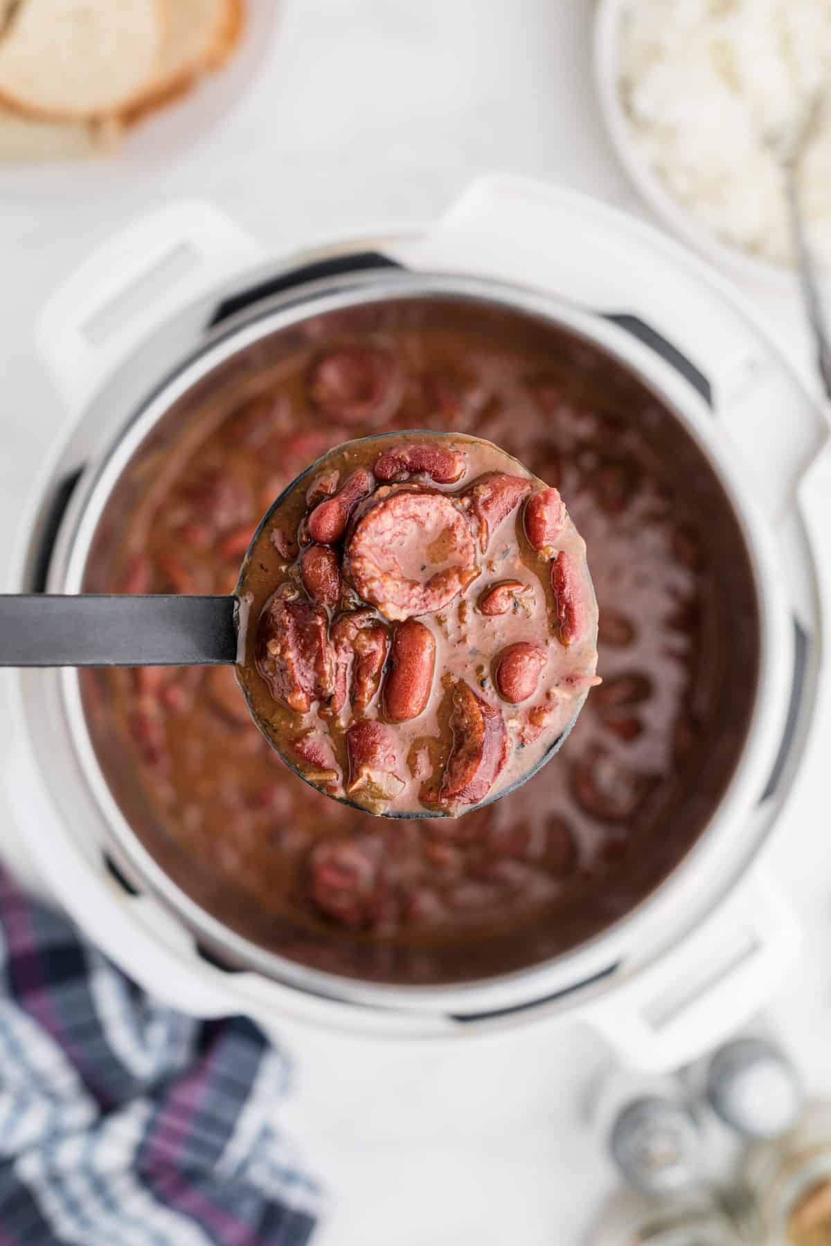 A ladel is scooping a serving of red beans from the instant pot.