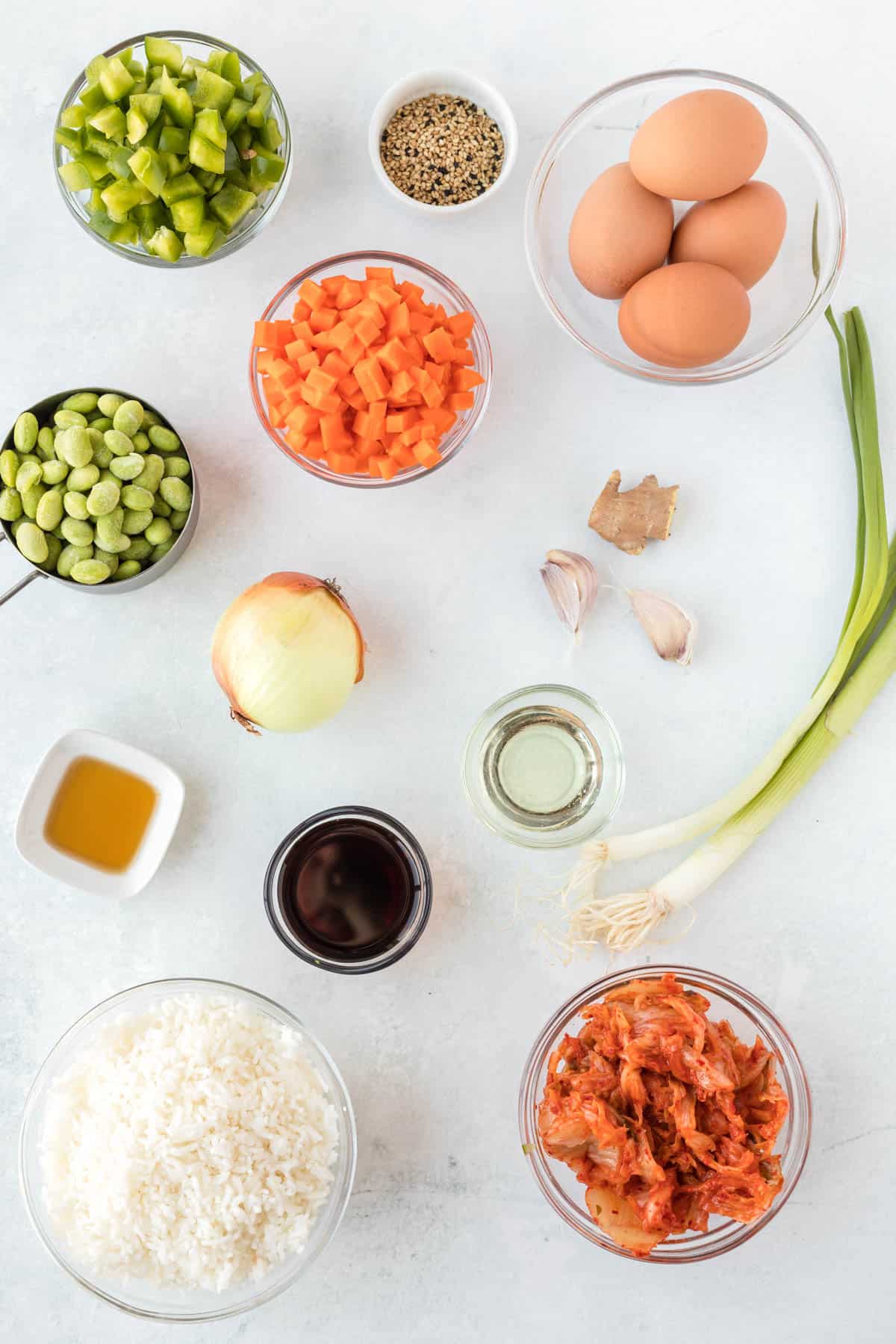 The ingredients for kimchi are spread out on a white surface.