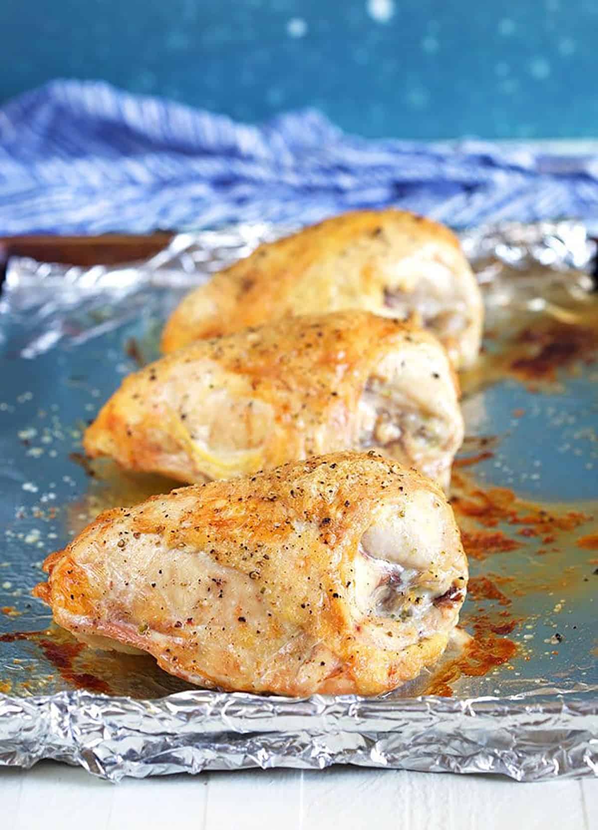 Roasted chicken breast on a baking sheet.