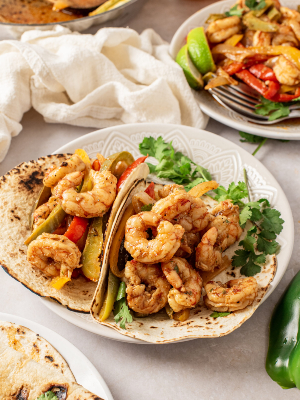 Two fajitas are placed on a white plate.