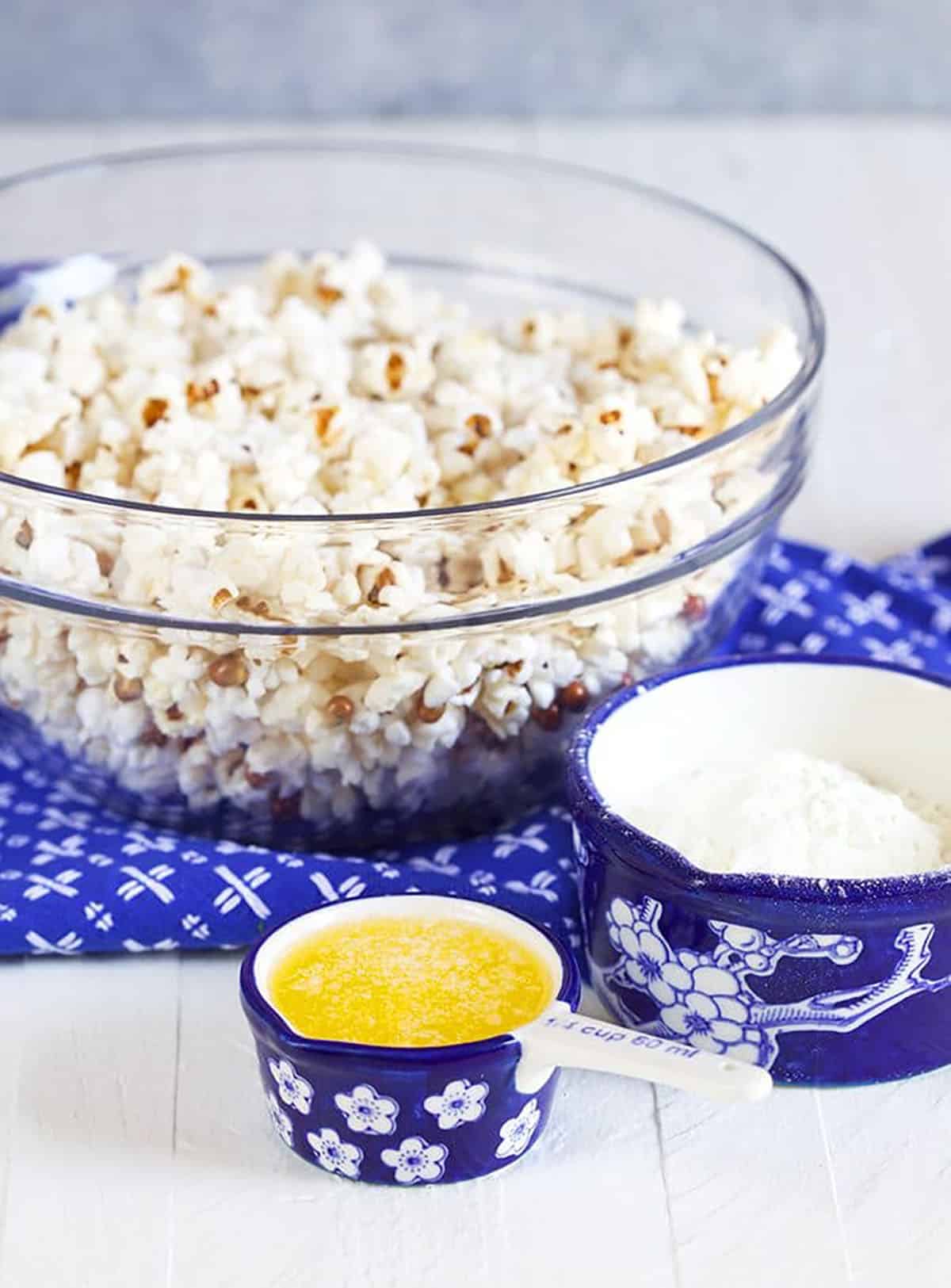 White cheddar popcorn in a red bowl on a blue napkin.