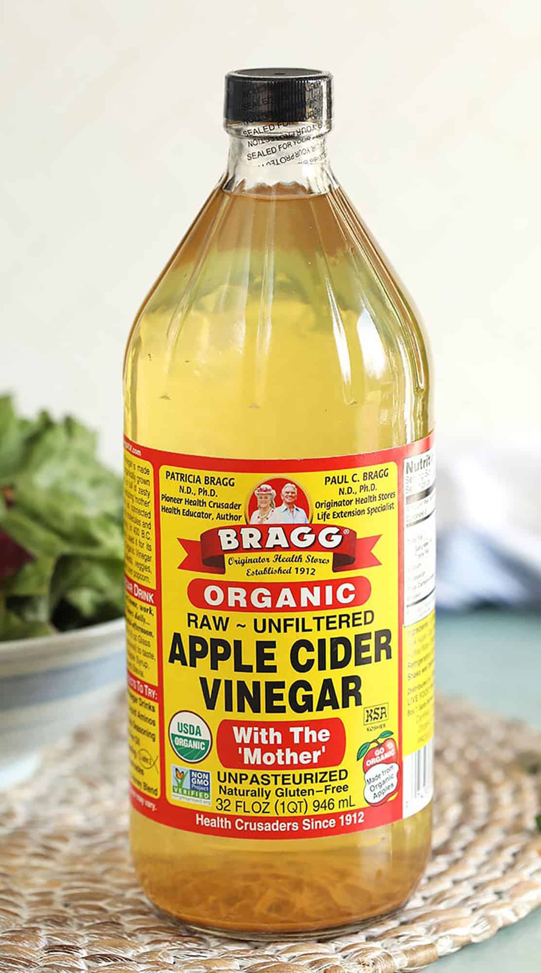 Bragg Apple Cider vinegar bottle on a wicker placemat.