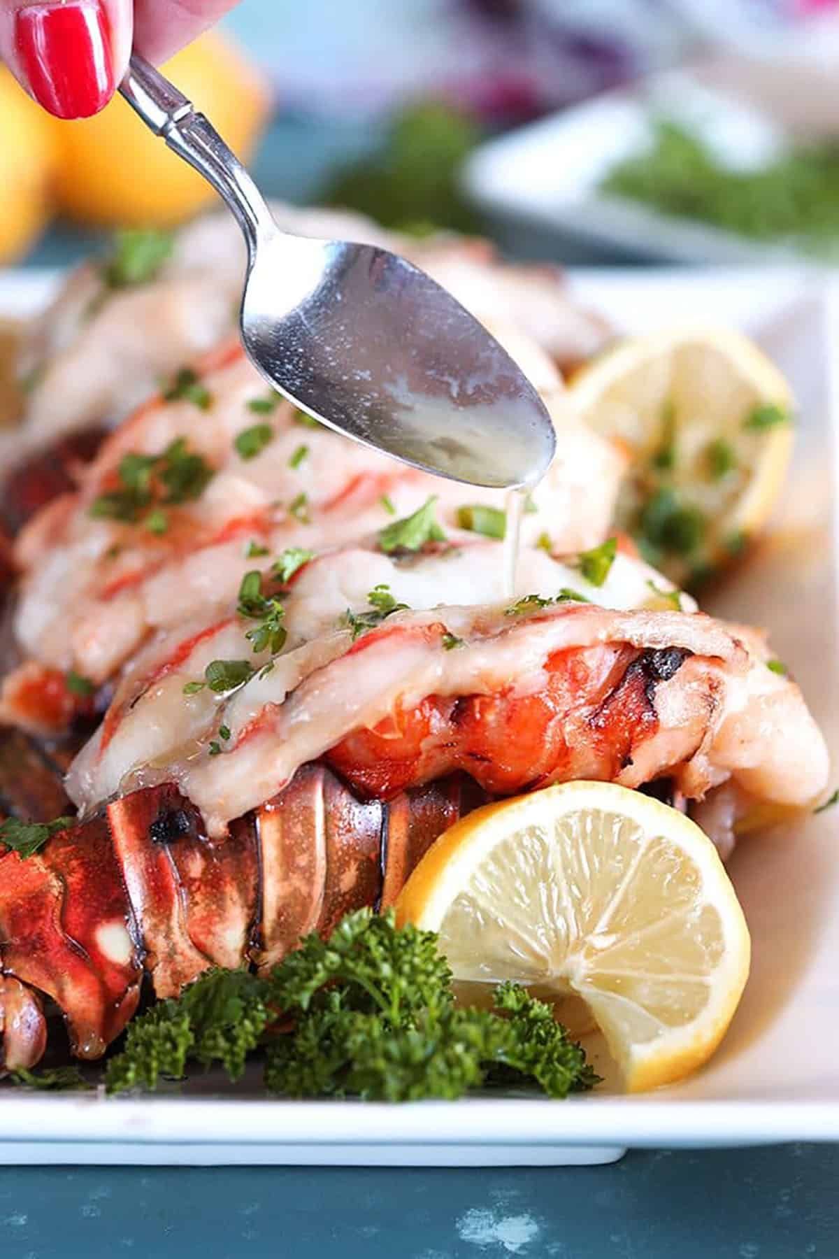Baked Lobster Tail being drizzled with melted butter.