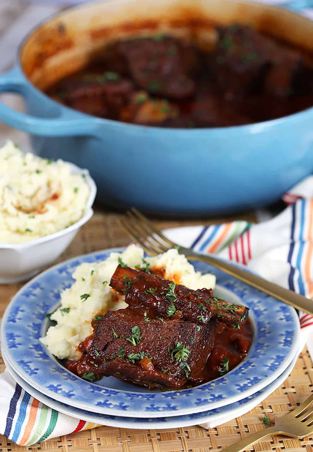 Braised Short Ribs on a blue plate with mashed potatoes