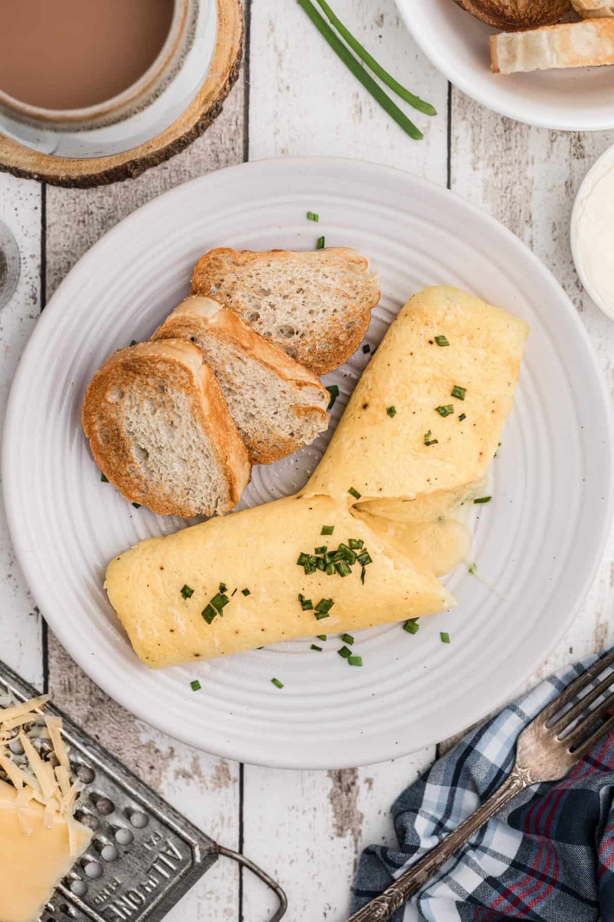 A french omelette is plated with three pieces of crostini.