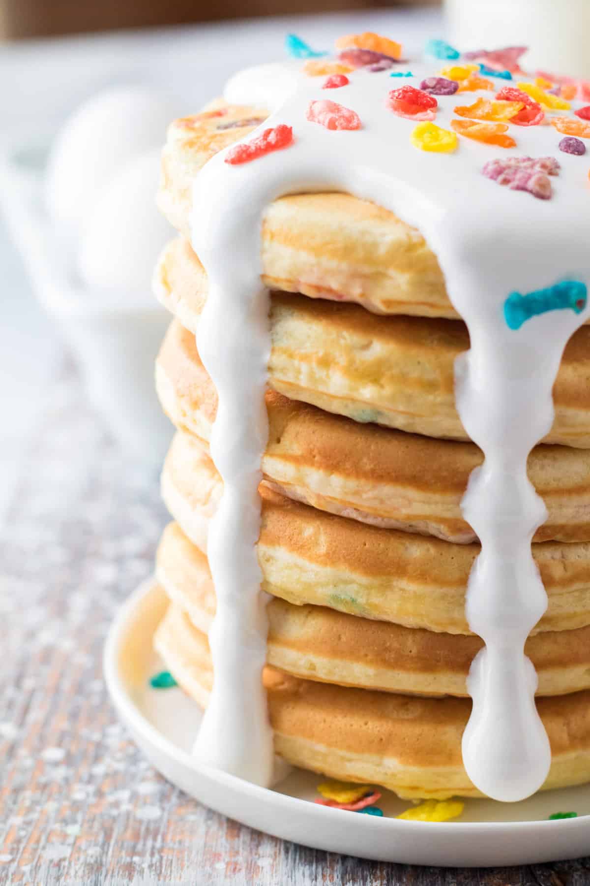A stack of pancakes is topped with a generous amount of marshmallow fluff on a white plate.