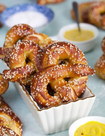 Soft pretzels in a white baking dish on a blue background.