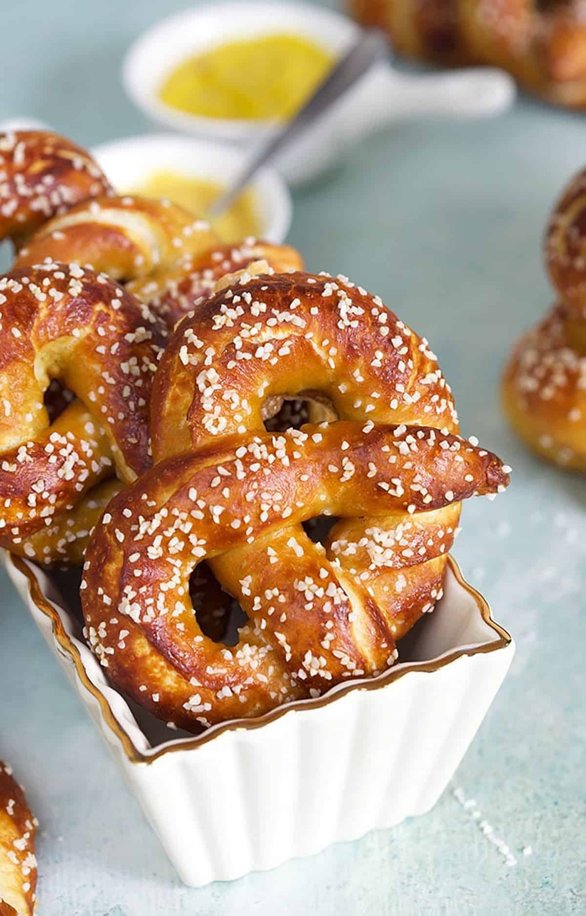 Soft Pretzels in a white baking dish with mustard in the background.