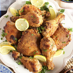 Crispy Oven Fried Chicken on a white square platter with lemon slices.