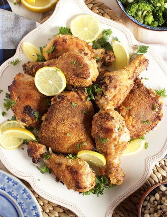 Crispy Oven Fried Chicken on a white square platter with lemon slices.