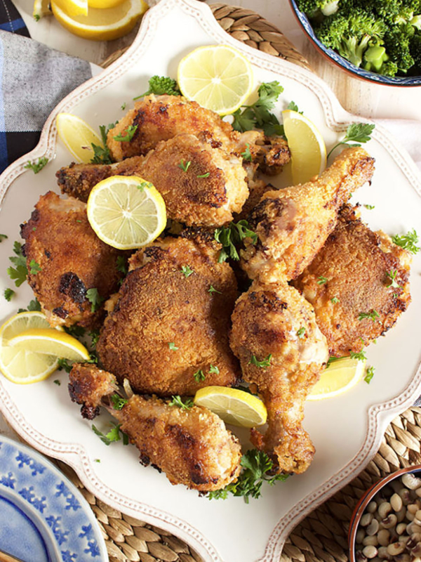 Crispy Oven Fried Chicken on a white square platter with lemon slices.