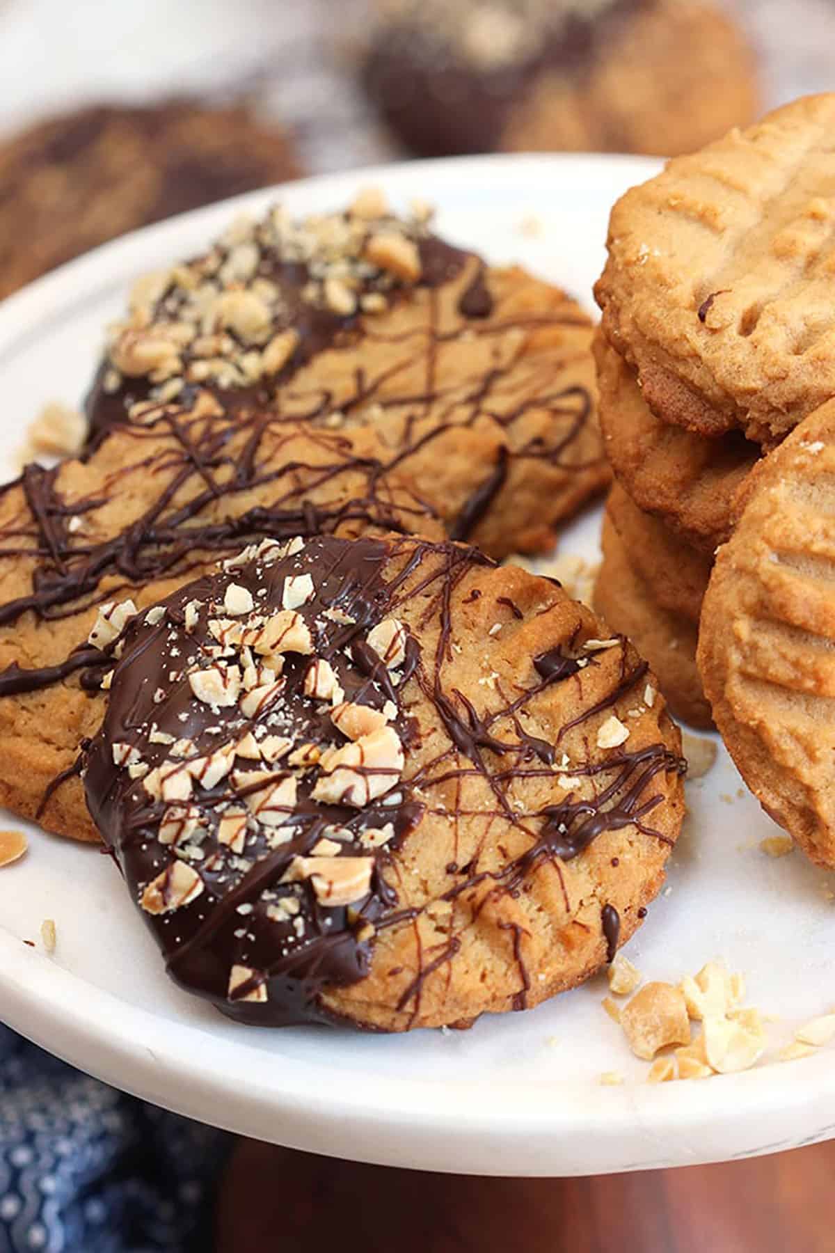 Peanut butter cookie dipped in chocolate on a plate with other peanut butter cookies.