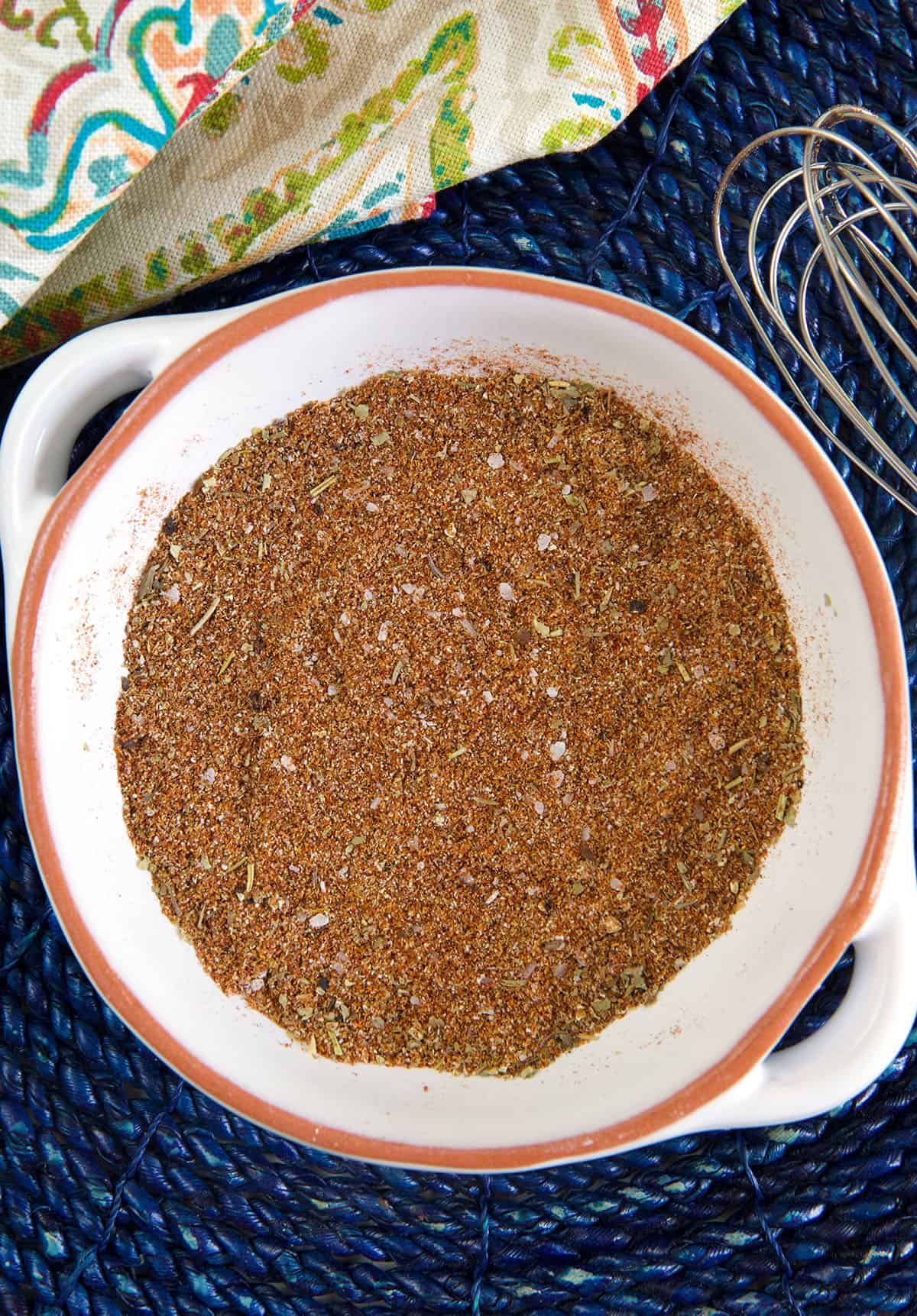 A white bowl is filled with homemade chili seasoning.