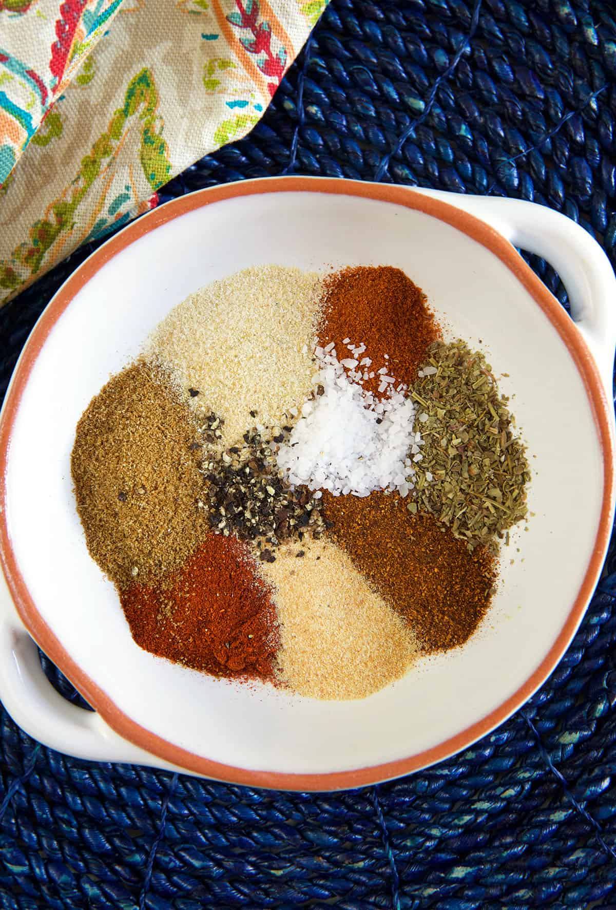 The ingredients for chili seasoning are placed next to each other in a white bowl.