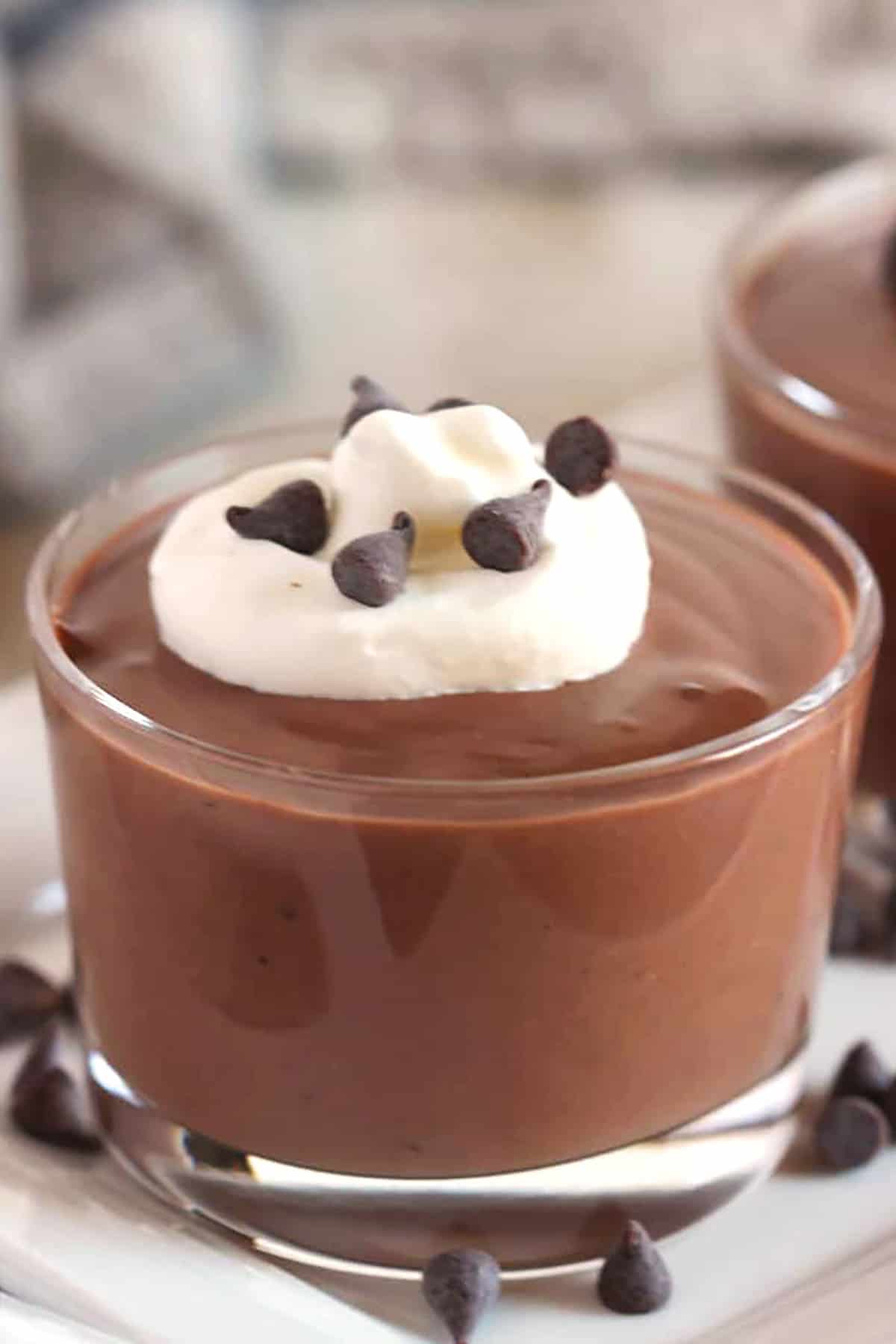 One small glass dish with chocolate pudding topped with whipped cream.