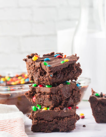 A stack of three brownies is presented on a countertop.