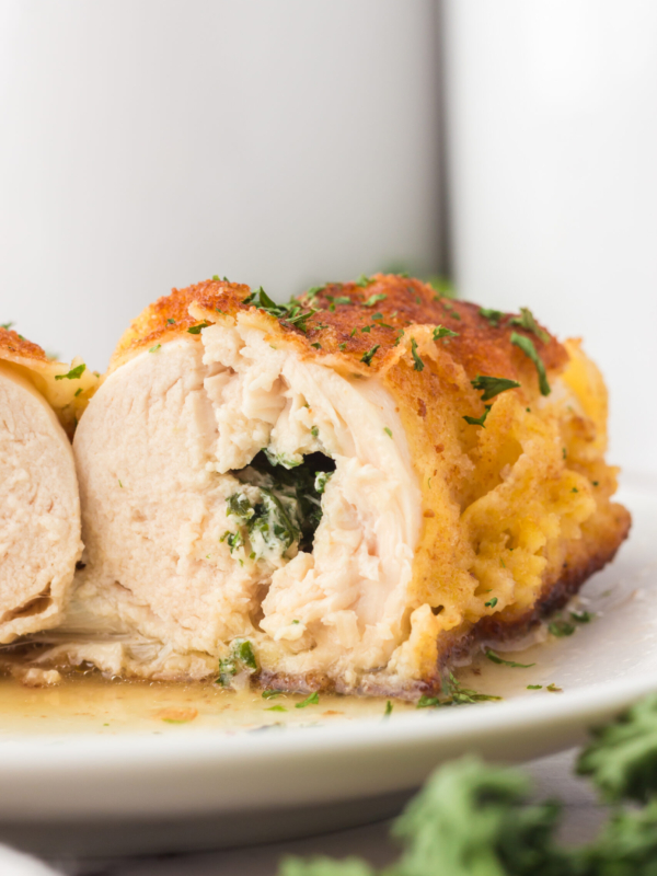 A piece of chicken has been cut in half to reveal a stuffed center.