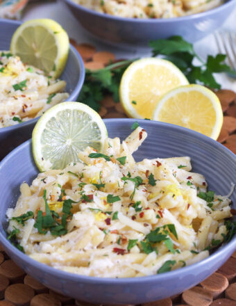 A blue bowl is filled with lemon ricotta pasta.