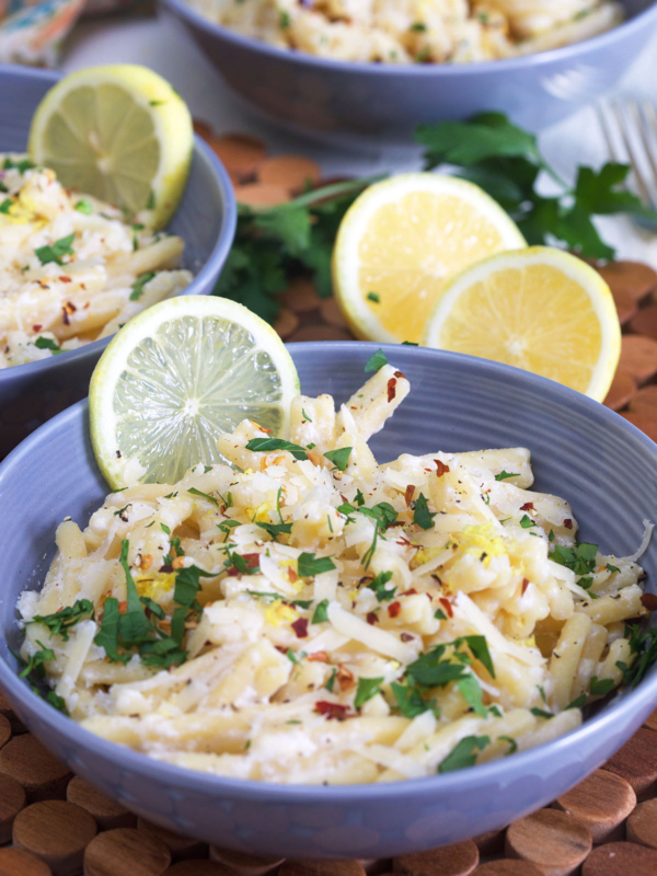 A blue bowl is filled with lemon ricotta pasta.