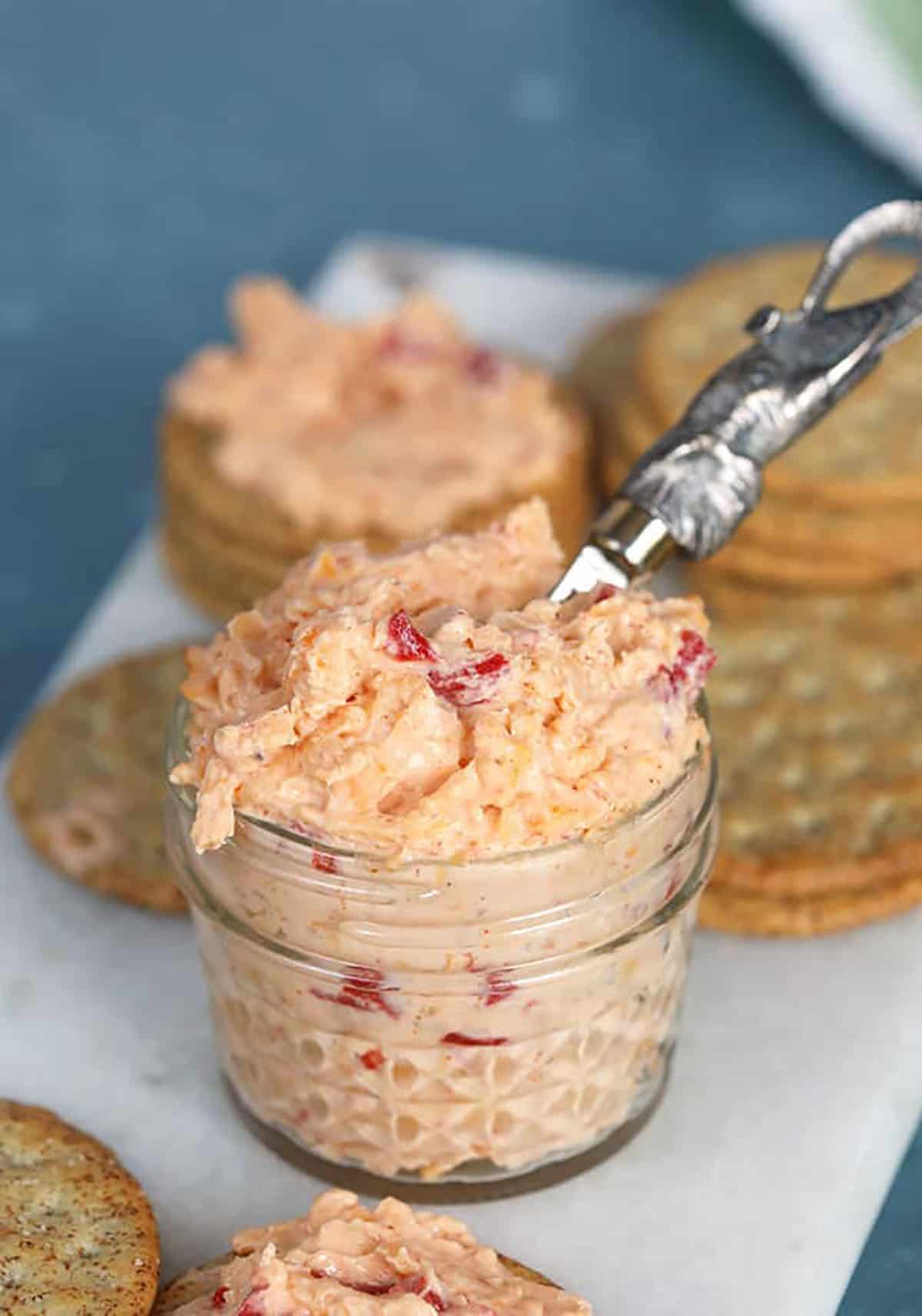Pimento Cheese in a glass jar with a silver elephant spreader 