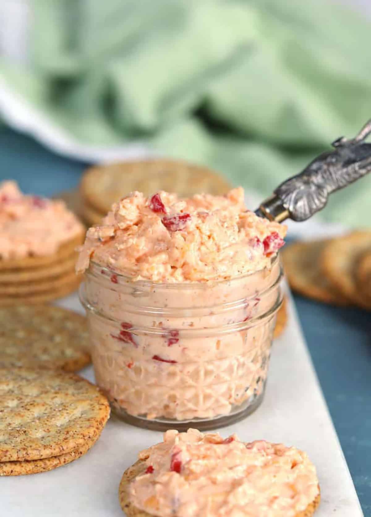 Pimento Cheese in a small jar with a spreader and green napkin