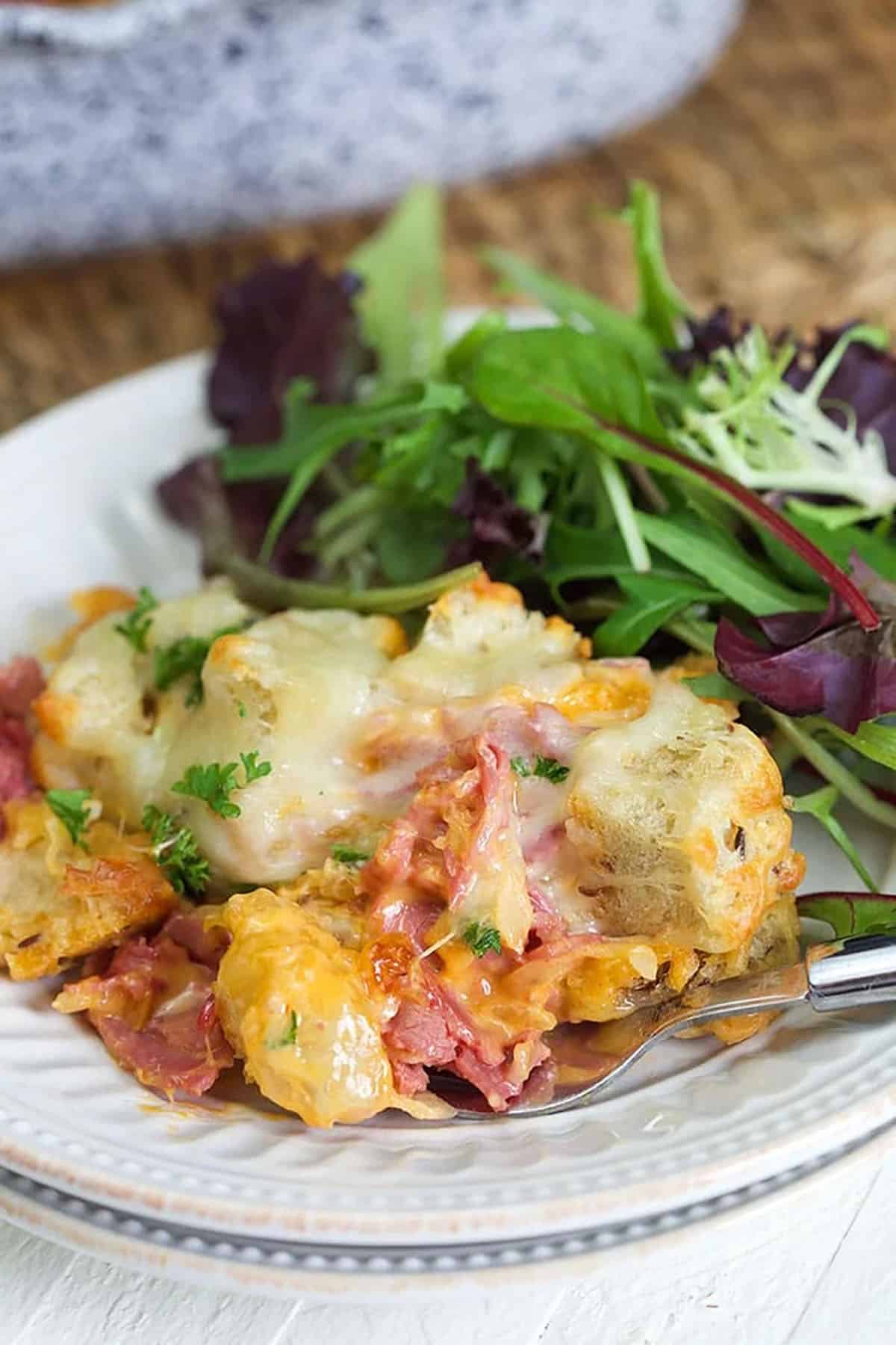 Reuben casserole on a plate with a salad.