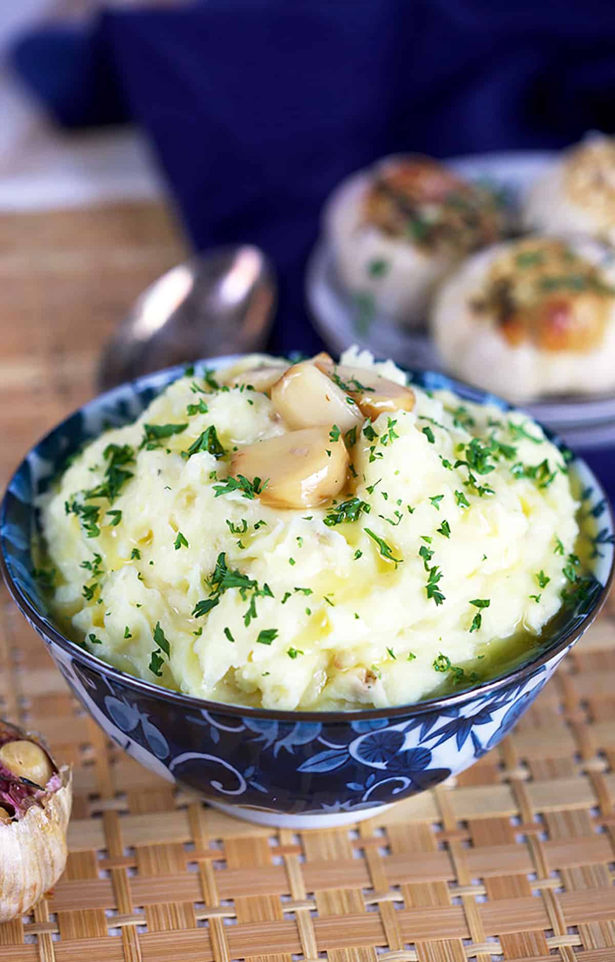 Roasted Garlic Mashed Potatoes in a blue and white bowl with parsley. 