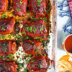 Overhead shot of bbq chicken on a baking sheet lined with aluminum foil.