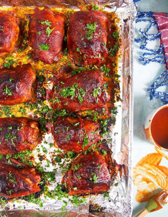 Overhead shot of bbq chicken on a baking sheet lined with aluminum foil.