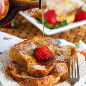 French Toast on a white plate with syrup being drizzled on top