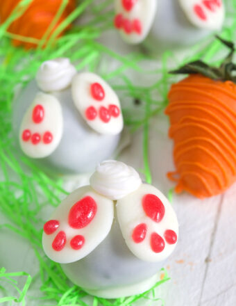 Several bunny butt truffle are placed next to Easter strawberries.