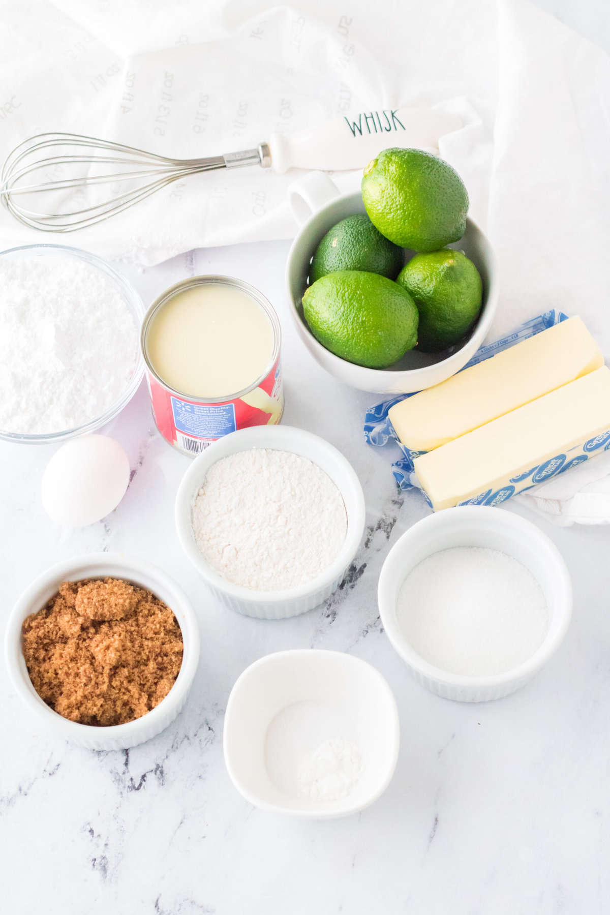 The ingredients for key lime pie cookies are presented on a white countertop.