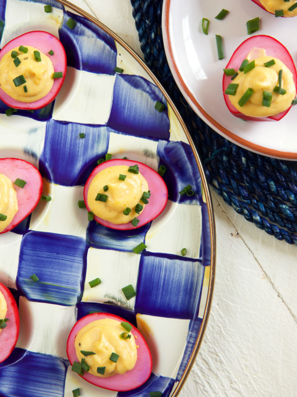 Two plates topped with deviled eggs are placed next to one another.