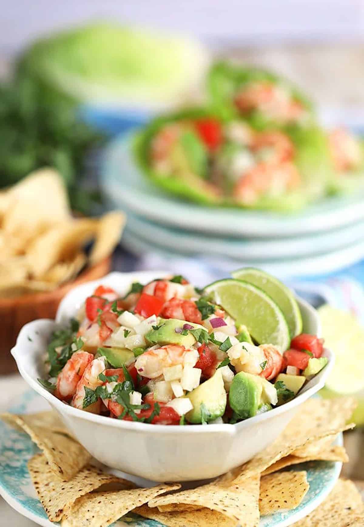 Shrimp ceviche with avocado in a white bowl with chips